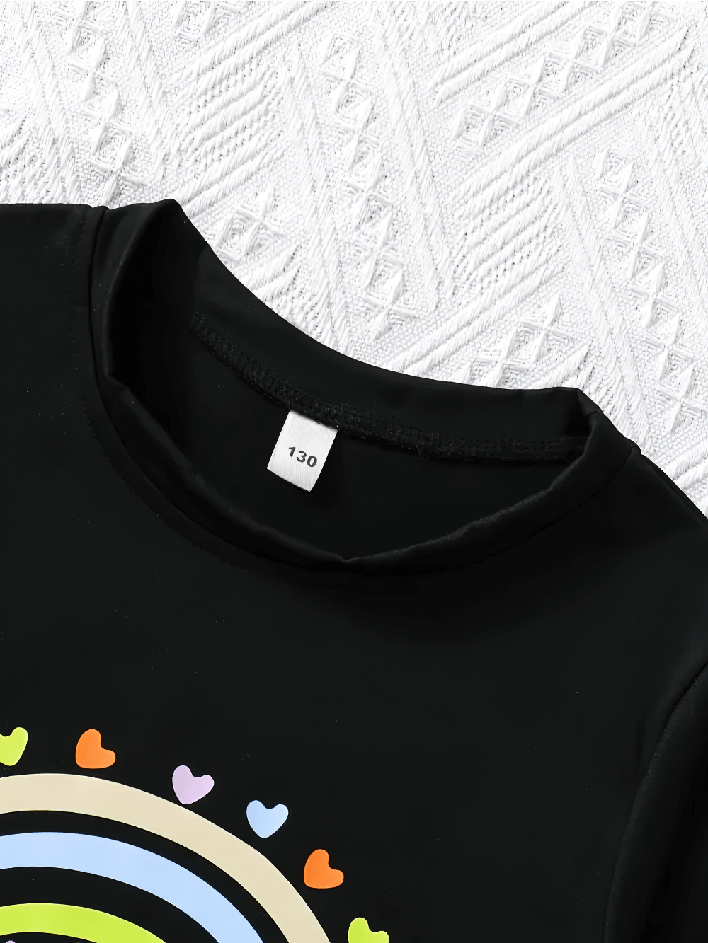 Close-up of Rainbow Heart Print Short-Sleeved T-Shirt - SF3593, showing colorful rainbow heart design on black fabric.
